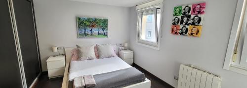 a small bedroom with a bed and two windows at A 50 metros del Paseo Marítimo in A Coruña