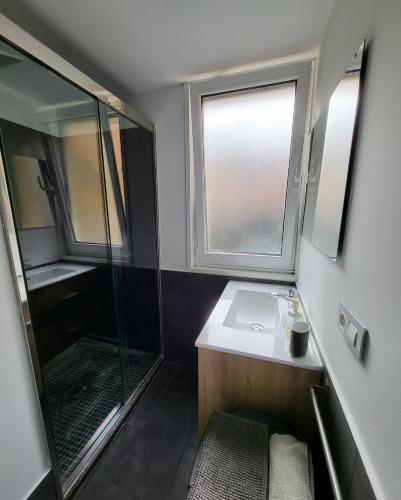 ein Bad mit einer Dusche, einem Waschbecken und einem Spiegel in der Unterkunft A 50 metros del Paseo Marítimo in A Coruña