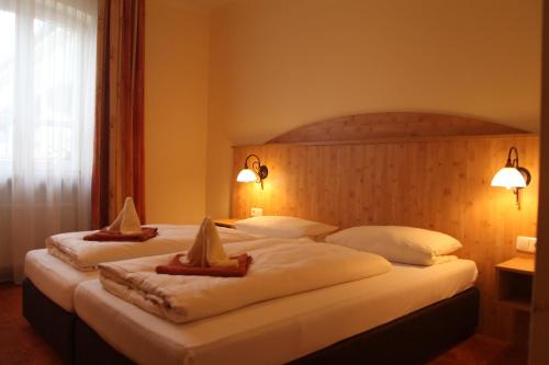 two beds in a hotel room with towels on them at Landgasthof Ostermair in Petershausen