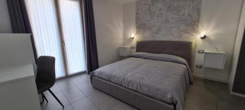 een slaapkamer met een bed met een stenen muur bij Elements B&B in Azzano San Paolo