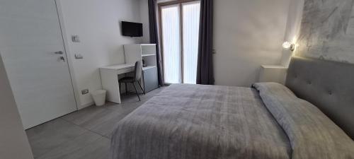 een slaapkamer met een groot bed en een bureau bij Elements B&B in Azzano San Paolo