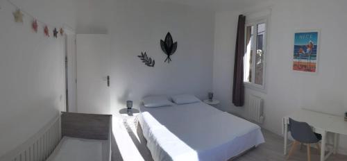 une chambre blanche avec un lit et un bureau dans l'établissement Villa Lina Zoï, à Nice
