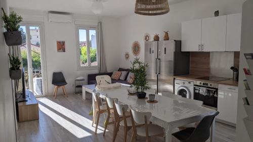 une cuisine et un salon avec une table et des chaises blanches dans l'établissement Villa Lina Zoï, à Nice