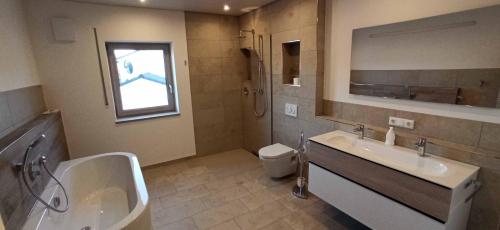 a bathroom with a sink and a tub and a toilet at Ferienwohnung flussendlich in Beilngries