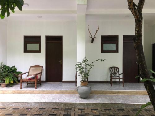 a room with two chairs and a door and a tree at No 44,Anniewatte Road in Kandy