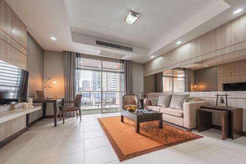 a living room with a couch and a table at Grand Asoke Suites Boutique Residence in Bangkok