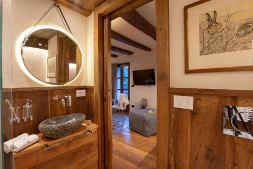 bagno con lavandino e specchio di L.A. SUITE Courmayeur a Courmayeur