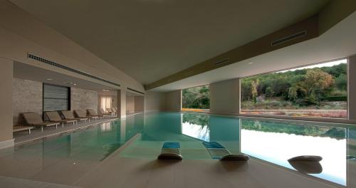 una gran piscina con 2 sillas y 2 ventanas en Basiliani - CDSHotels, en Otranto