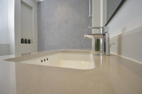 eine Küche mit einer Spüle und einem Wasserhahn auf der Theke in der Unterkunft bnbmehomes - Elegant 3 BR - Dubai South - G04 in Dubai