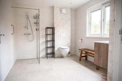 uma casa de banho com um chuveiro, um WC e um lavatório. em Het Mienterbos em De Koog