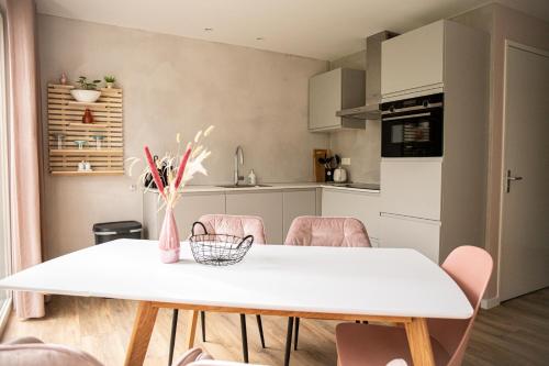 a kitchen and dining room with a white table and chairs at Het Mienterbos in De Koog