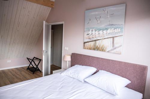 ein Schlafzimmer mit einem Bett und einem Wandgemälde in der Unterkunft Het Mienterbos in De Koog