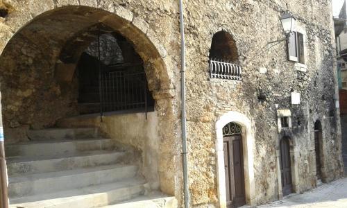 a stone building with stairs next to a door at Casa MAMMUCCIA in Calascio