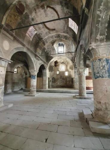 a large room with a stone floor and ceilings at Deep Cave House in Urgup