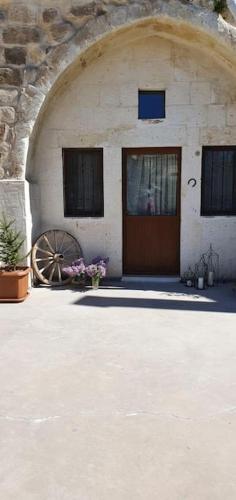 a building with a wooden door and a large wheel at Deep Cave House in Urgup