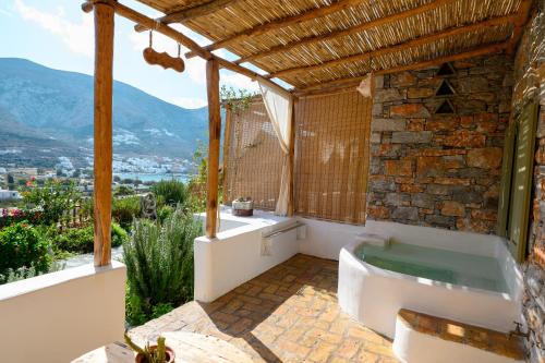 a bathroom with a bath tub and a window at Aliori art caves in Aegiali