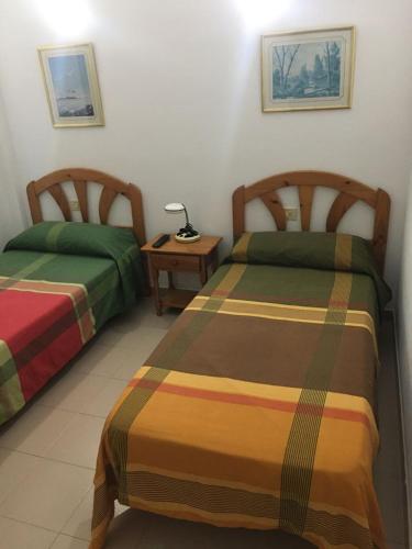 a room with two beds and a table with a lamp at Apto Tagoro, La Restinga in La Restinga