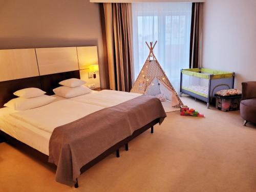 a bedroom with a large bed and a christmas tree at Ruben Hotel Zielona Góra in Zielona Góra