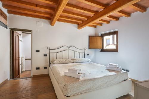 ein Schlafzimmer mit einem großen Bett in einem Zimmer mit Holzdecken in der Unterkunft UFFIZI Suite I in Florence-hosted by Sweetstay in Florenz