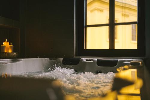 a bath tub filled with water in front of a window at SAVOY residence in Osijek