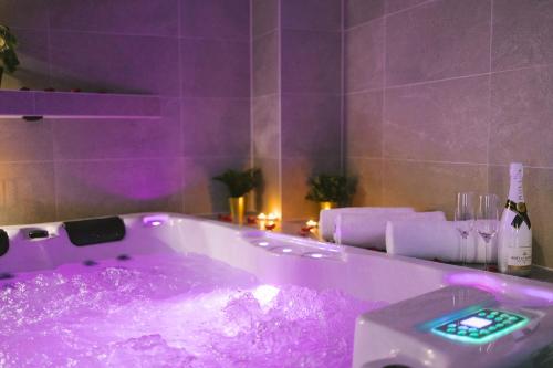 a purple bathroom with a tub filled with purple liquid at SAVOY residence in Osijek