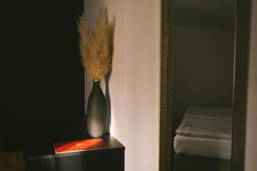 a vase sitting on a table next to a mirror at SAVOY residence in Osijek