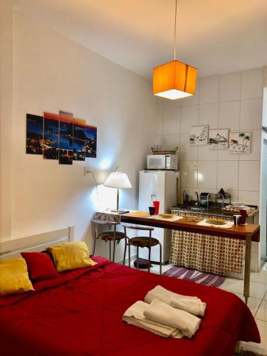 a bedroom with a red bed and a kitchen at Lapa II Cultura Museus e Praias no Centro GR in Rio de Janeiro