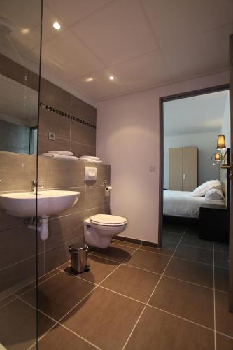 une salle de bain avec toilettes et lavabo et un lit dans l'établissement Hôtel Restaurant les Pielettes, à Le Rove