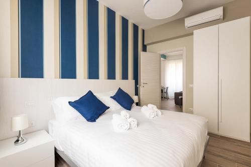 una camera da letto con un grande letto bianco con cuscini blu di IL CONTE Piazza Signoria-Hosted by Sweetstay a Firenze