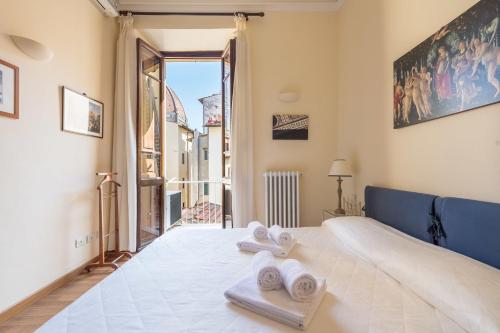 sypialnia z dużym łóżkiem z ręcznikami w obiekcie CHARMING 2BED APARTMENT overlooking DUOMO - hosted by Sweetstay we Florencji