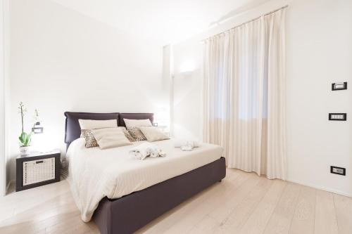 フィレンツェにあるPRESTIGE Apartment - hosted by Sweetstayの白いベッドルーム(ベッド1台、タオル2枚付)