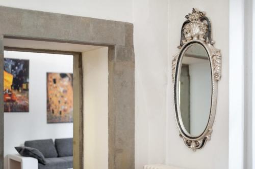 a mirror on the wall of a living room at Pontevecchio Luxury Suite AMAZING LOCATION - hosted by Sweetstay in Florence