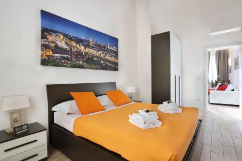 una camera da letto con un grande letto con cuscini arancioni di IL GRANDUCA New Apartment in Amazing Location - hosted by Sweetstay a Firenze