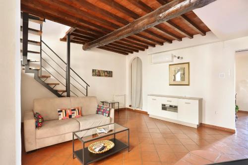 佛羅倫斯的住宿－TORNABUONI apartment- hosted by Sweetstay，带沙发和楼梯的客厅