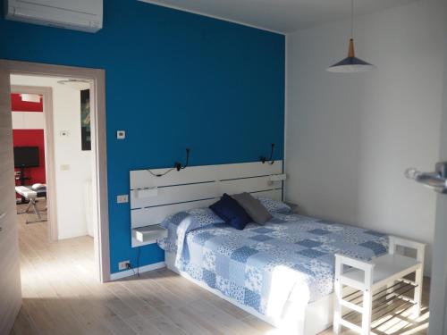 een slaapkamer met een blauwe muur en een bed bij Victoria House Venice in Mestre