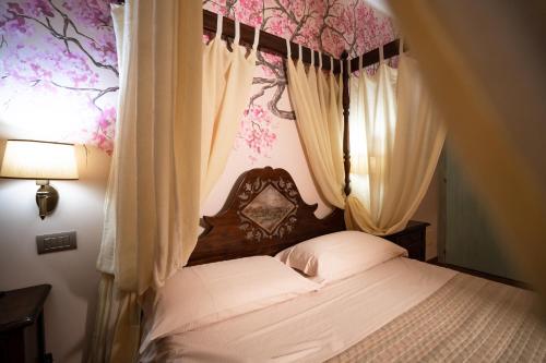 a bedroom with a canopy bed with flowers on the wall at Villa D'Anzi B&B in Ginosa