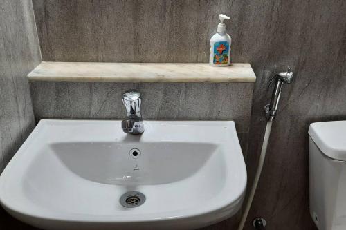 a bathroom with a white sink and a toilet at Tata Housing Rio De Goa in Marmagao