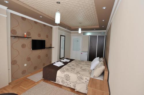 a bedroom with a bed and a tv on a wall at Apartments 4 seasons in Ohrid