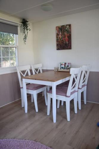 a white dining room table and chairs in a room at Chalet Heggemus Oisterwijk in Oisterwijk