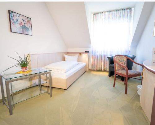 a hotel room with a bed and a table and a chair at Hotel Tanne in Saalfeld