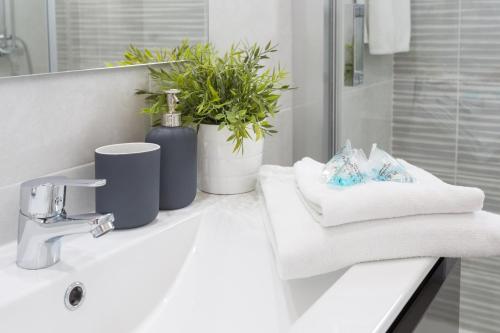 a bathroom with a sink with towels and a plant at VIME La Reserva de Marbella in Marbella
