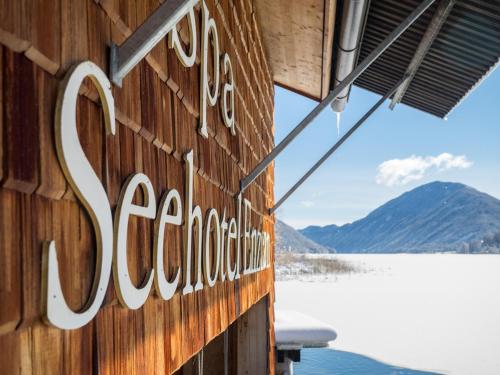 a sign on the side of a building next to a lake at Landhaus Sonneck in Weissensee