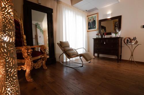 a room with a chair and a mirror and a dresser at Villa D'Anzi B&B in Ginosa