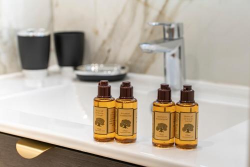 four bottles of essential oils sitting on a bathroom sink at Frontière Monaco, Studio rénové - AE in Beausoleil