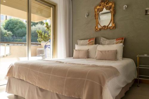 a bedroom with a large bed with a mirror on the wall at Appartement proche mer et gare in Cannes
