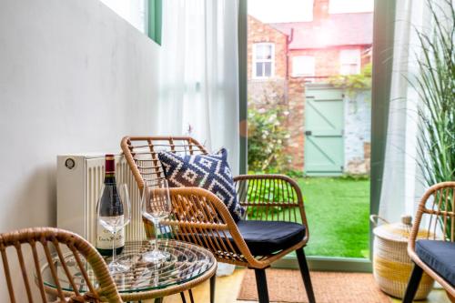 a patio with a table and chairs and a bottle of wine at Farndale Den in York