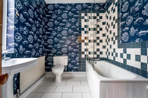 a bathroom with a toilet and a tub and a sink at Farndale Den in York