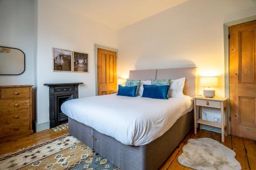 a bedroom with a large bed with blue pillows at Farndale Den in York