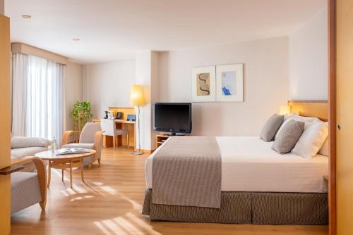 a hotel room with a bed and a living room at Hotel Castellon Center Affiliated by Meliá in Castellón de la Plana