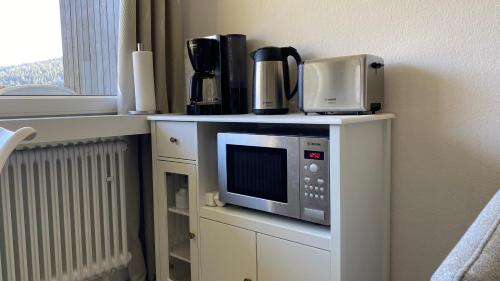 un four micro-ondes sur une étagère avec des appareils dans l'établissement Sofia, à Balderschwang